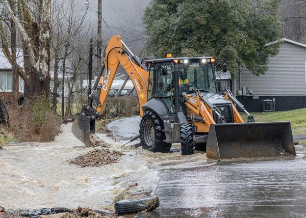 A state road crew cleared debris from a creek along Big Bottom Hollow Road in Campbells Creek, just outside of Charleston, W.Va.,, after flood waters came across the roadway and entered the nearby Mary Ingles Elementary School on Thursday Feb. 6, 2025. (Sean McCallister