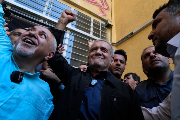 FILE - Reformist candidate for the Iran's presidential election Masoud Pezeshkian clenches his fist after casting his vote as he is accompanied by former Foreign Minister Mohammad Javad Zarif, left, at a polling station in Shahr-e-Qods near Tehran, Iran, Friday, July 5, 2024. (AP Photo/Vahid Salemi, File)