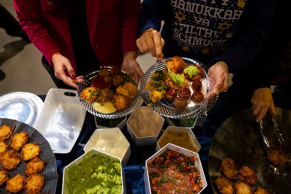 Guests add guacamole and pico de gallo to latkes during a Chicanukah event at Holocaust Museum Houston on Thursday, December 19, 2024, in Houston. (AP Photo/Annie Mulligan)