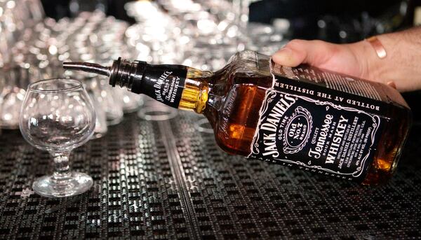 FILE - In this March 4, 2011, file photo, a bartender begins to pour a drink from a bottle of Jack Daniels at a bar in San Francisco. (AP Photo/Paul Sakuma, File)