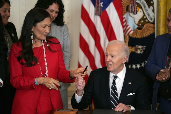 President Joe Biden hands Interior Secretary Deb Haaland a pen after signing a proclamation to establish the Chuckwalla National Monument and the Sáttítla Highlands National Monument during an event in the East Room of the White House, Tuesday, Jan. 14, 2025, in Washington. (AP Photo/Evan Vucci)