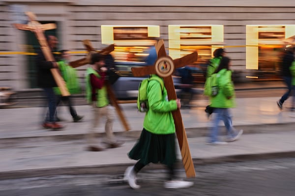 Volunteers carry wooden crosses near St. Peter's Square in Rome, Italy, Friday, March 7, 2025. (AP Photo/Francisco Seco)