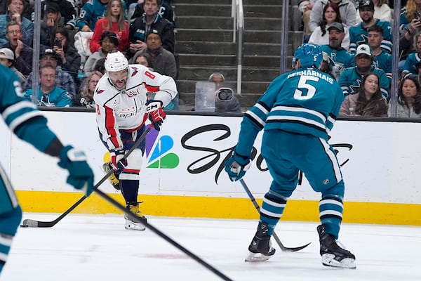 Washington Capitals left wing Alex Ovechkin (8) shoots at the goal against San Jose Sharks defenseman Vincent Desharnais (5) during the second period of an NHL hockey game in San Jose, Calif., Saturday, March 15, 2025. (AP Photo/Tony Avelar)