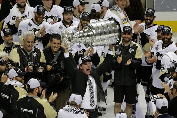 FILE - Pittsburgh Penguins head coach Mike Sullivan raises the Stanley Cup after Game 6 of the NHL hockey Stanley Cup Finals against the San Jose Sharks in San Jose, Calif, June 12, 2016. (AP Photo/Eric Risberg, File)