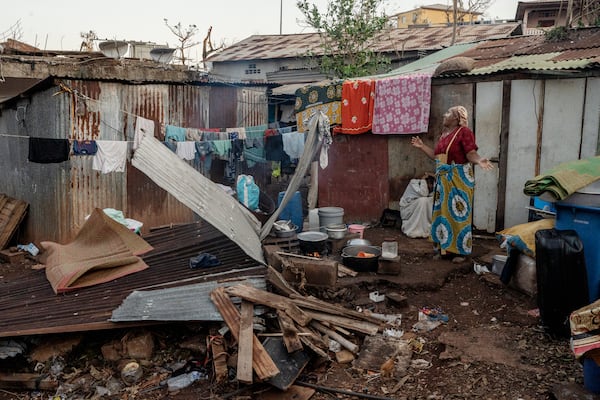 A woman stands in her destroyed house in Mamoudzou, Mayotte, Thursday, Dec. 19, 2024 (AP Photo/Adrienne Surprenant)