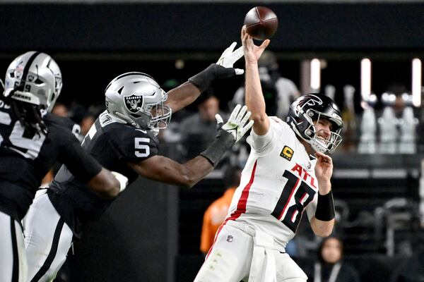 Atlanta Falcons quarterback Kirk Cousins (18) throws under pressure from Las Vegas Raiders linebacker Divine Deablo (5) during the first half of an NFL football game, Monday, Dec. 16, 2024, in Las Vegas. (AP Photo/David Becker)