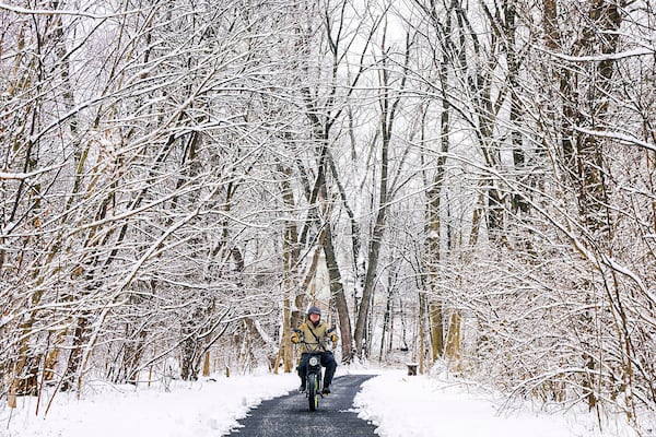 Jose Escobar rides his motorized bicycle on the trails in Rock Creek Park in Frederick, Md. on Wednesday, Feb. 12, 2025, after snowfall overnight. Parts of the area received 2-4 inches of snow. (Ric Dugan/The Frederick News-Post via AP)