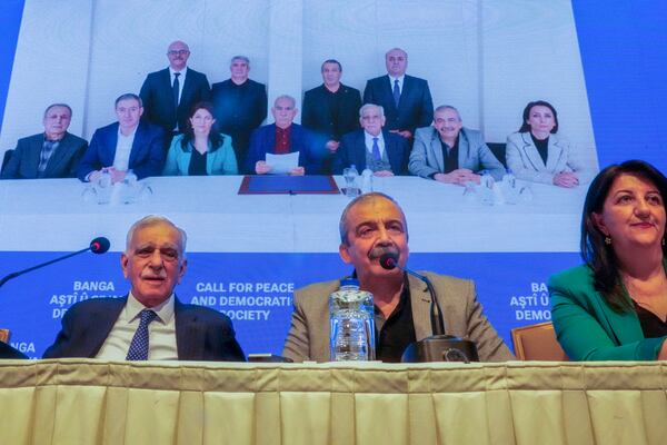 Pro-Kurdish Peoples' Equality and Democracy Party, or DEM, delegation members release an statement from the jailed leader of the rebel Kurdistan Workers' Party, or PKK, Abdullah Ocalan, center at the background photo, in Istanbul, Turkey, Thursday, Feb. 27, 2025. (AP Photo/Khalil Hamra)