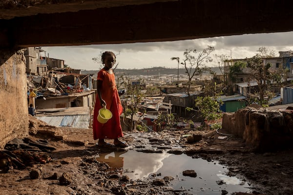 A young girl walks in the Kaweni slum on the outskirts of Mamoudzou, in the French Indian Ocean island of Mayotte, Thursday, Dec. 19, 2024, after Cyclone Chido. (AP Photo/Adrienne Surprenant)