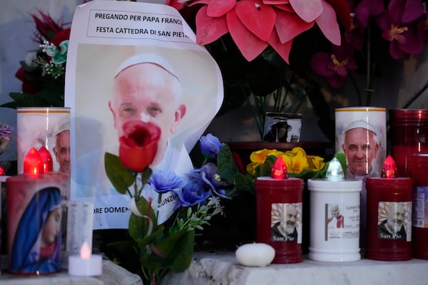 Candles are seen near pictures of Pope Francis outside the Agostino Gemelli Polyclinic in Rome, Sunday, Feb. 23, 2025, where the Pontiff is hospitalized since Feb. 14. (AP Photo/Gregorio Borgia)