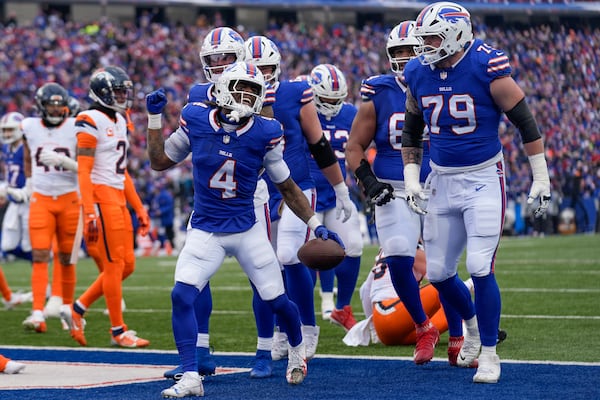 Buffalo Bills running back James Cook (4) celebrates with teammates after scoring a touchdown against the Denver Broncos during the second quarter of an NFL wild card playoff football game, Sunday, Jan. 12, 2025, in Orchard Park, N.Y. (AP Photo/Seth Wenig)