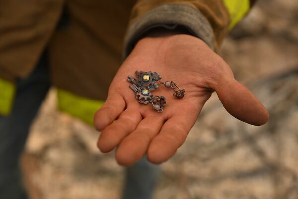 Robert Lara holds one of his great grandmother's burned earrings at his home that was destroyed after the Eaton Fire burns in Altadena, Calif., Thursday, Jan. 9, 2025. (AP Photo/Nic Coury)