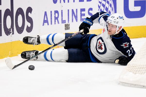 Winnipeg Jets left wing Nikolaj Ehlers (27) reaches for the puck during the second period of an NHL hockey game against the Washington Capitals, Saturday, Feb. 1, 2025, in Washington. (AP Photo/Nick Wass)