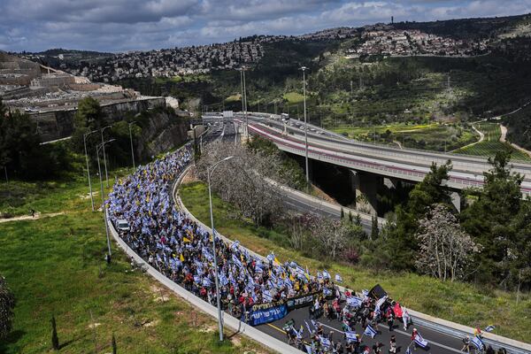 Israelis march on a highway toward Jerusalem to protest Prime Minister Benjamin Netanyahu's plans to dismiss the head of the Shin Bet internal security service, on Wednesday, March 19, 2025. (AP Photo/Ohad Zwigenberg)