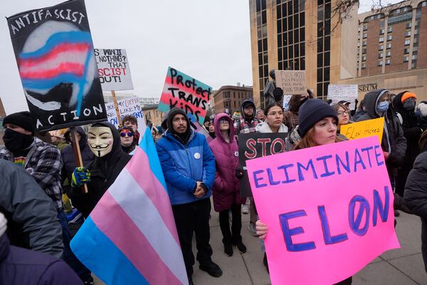 People hold up signs during a protest outside the Wisconsin Capitol Wednesday, Feb. 5, 2025, in Madison, Wis. (AP Photo/Morry Gash)