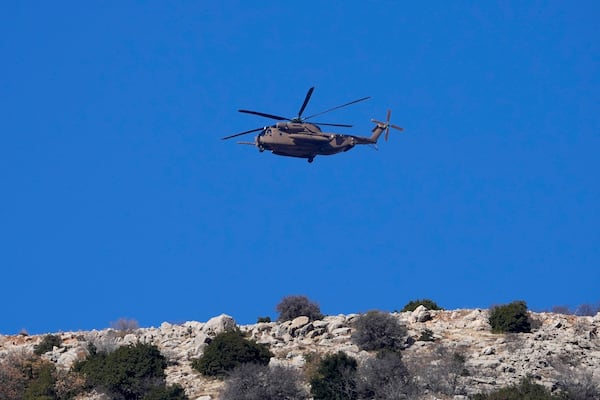 An Israeli Air Force Black Hawk helicopter flies over Mount Hermon near the so-called Alpha Line that separates the Israeli-controlled Golan Heights from Syria, viewed from the town of Majdal Shams, Tuesday, Dec. 17, 2024. (AP Photo/Matias Delacroix)