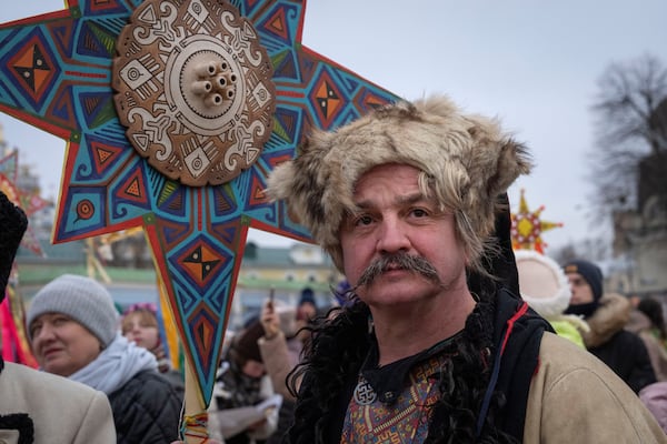 A man wearing a national costume celebrates Christmas near St. Michael Monastery in a city centre in Kyiv, Ukraine, Wednesday, Dec. 25, 2024. (AP Photo/Efrem Lukatsky)