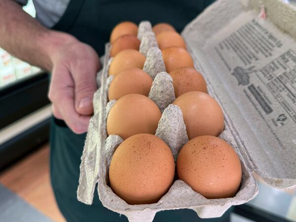 FILE - Joe Trimble, owner of Encinal Market, holds an open carton of eggs in Alameda, Calif., on Tuesday, Feb. 11, 2025. (AP Photo/Terry Chea, File)