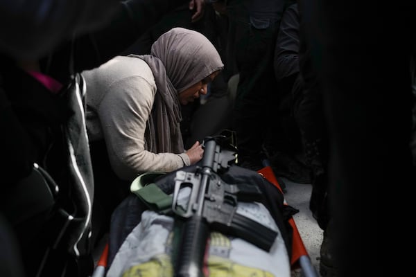 A mourner cries while she takes the last look at the body of a relative, one of eight Palestinians killed, during their funeral following the withdrawal of the Israeli army, in the West Bank city of Tulkarem, Thursday, Dec. 26, 2024. (AP Photo/Matias Delacroix)