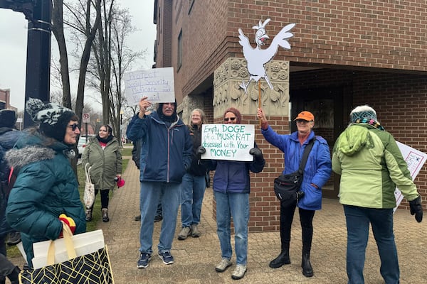 Protesters gather outside Rep. Bill Huizenga's office in Holland, Mich., on Friday, March 7, 2025, to protest the Republican not holding an in-person town hall. (AP Photo/Joey Cappelletti)