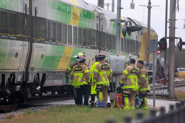 Firemen gather after Brightline train collided with a fire truck in downtown Delray Beach, Fla., Saturday, Dec. 28, 2024. (Mike Stocker/South Florida Sun-Sentinel via AP)