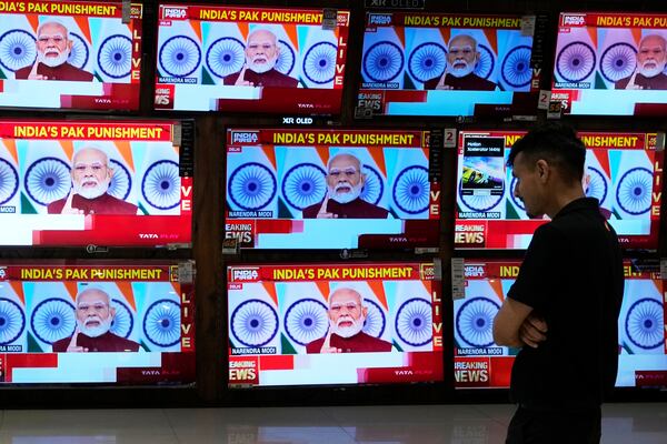 A man watches the live telecast of Indian Prime Minister Narendra Modi's speech on television screens at a shopping mall after 'Operation Sindoor' in Mumbai, India, Monday, May 12, 2025. (AP Photo/Rajanish Kakade)