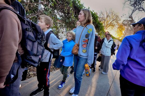 Palisades Charter Elementary School students and their parents arrive at their new school, the Brentwood Elementary Science Magnet school in the Brentwood section of Los Angeles on Wednesday, Jan. 15, 2025. (AP Photo/Richard Vogel)