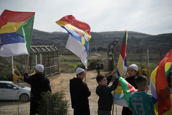 Members of the Druze community and clerics wait near the border for buses carrying members of the Syrian Druze community to cross from Syria in the village of Majdal Shams, in the Israeli-controlled Golan Heights, Friday, March 14, 2025. (AP Photo/Leo Correa)