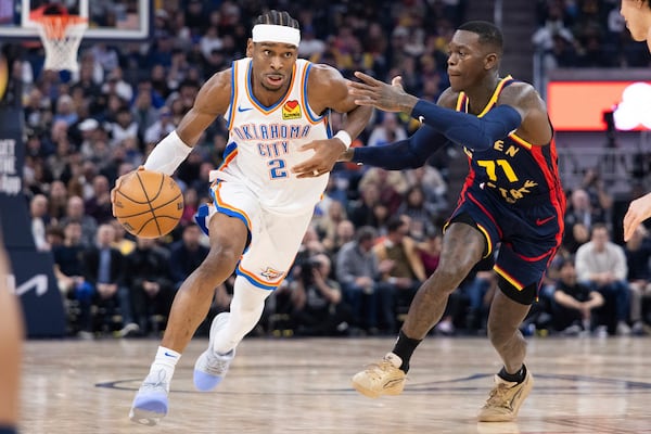 Golden State Warriors guard Dennis Schröder (71) defends against Oklahoma City Thunder guard Shai Gilgeous-Alexander during the first half of an NBA basketball game Wednesday, Jan. 29, 2025, in San Francisco. (AP Photo/Benjamin Fanjoy)