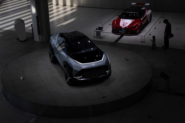 Visitors walk through a showroom at Nissan headquarters in Yokohama, Tuesday, May 13, 2025. (AP Photo/Louise Delmotte)