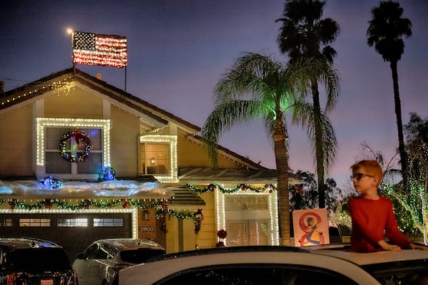 Local residents drive through the Wakefield Winter Wonderland neighborhood decorated with Christmas lights in Santa Clarita, Calif. on Dec. 17, 2024. (AP Photo/Richard Vogel)