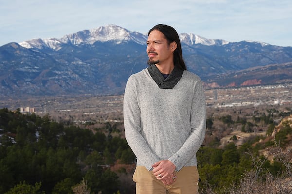 Lane Belone poses with Pikes Peak in the background on an overlook in Palmer Park, Thursday, Dec. 19, 2024, in Colorado Springs, Colo. (AP Photo/David Zalubowski)