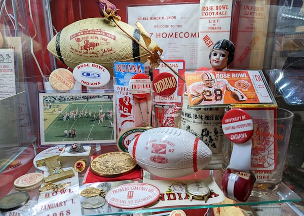 This 2022 image provided by Brett White shows a display of Indiana Hoosiers Rose Bowl sports memorabilia at White's home in Bloomington, Ind. White and other Indiana fans are riding the euphoria of a great season that culminated in a berth in the College Football Playoff. The Hoosiers will meet Notre Dame on Friday night in South Bend, Ind. (Brett White via AP)