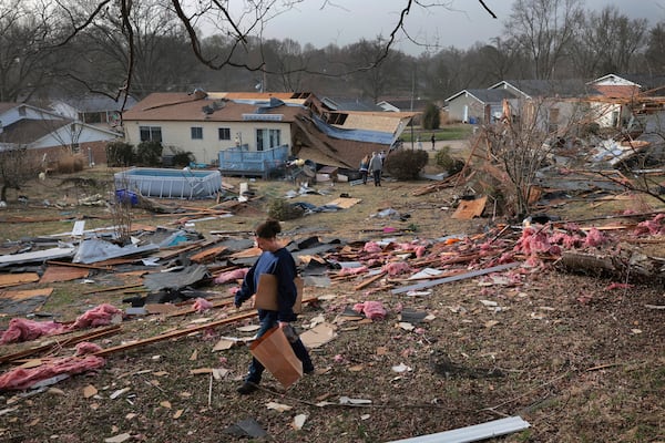 Missy, who declined to give her last name, searches for photographs in a debris field behind a relative's home after a severe storm in Bridgeton, Mo., Saturday, March 15, 2025. (Robert Cohen/St. Louis Post-Dispatch via AP)