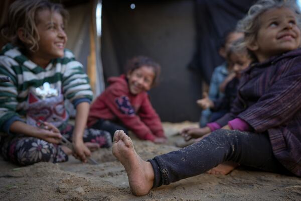 Grandchildren of Reda Abu Zarada, displaced from Jabaliya in northern Gaza, play next to their tent at a camp in Khan Younis, Gaza Strip, Thursday, Dec. 19, 2024. (AP Photo/Abdel Kareem Hana)