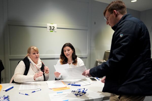 FILE - A caucus voter signs in at precinct 32 at Franklin Junior High in Des Moines, Iowa, Jan. 15, 2024. (AP Photo/Carolyn Kaster, File)