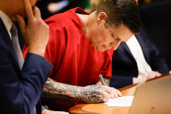 Jeffrey Nelson, an Auburn police officer convicted of murder for fatally shooting homeless man Jesse Sarey in 2019, signs a paper at his sentencing at the King County Maleng Regional Justice Center in Kent, Wash., Thursday, Jan. 23, 2025. (Karen Ducey/The Seattle Times via AP)