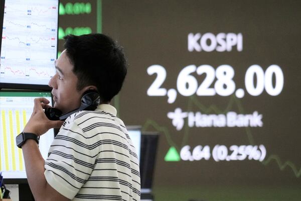 A currency trader talks on the phone near a screen showing the Korea Composite Stock Price Index (KOSPI) at the foreign exchange dealing room of the KEB Hana Bank headquarters in Seoul, South Korea, Friday, May 16, 2025. (AP Photo/Ahn Young-joon)