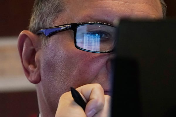 A trader's handheld device is reflected in his glasses on the floor of the New York Stock Exchange, Tuesday, March 11, 2025. (AP Photo/Richard Drew)