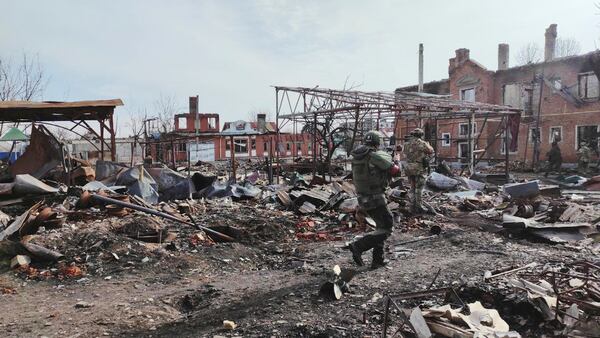 In this photo taken from video distributed by Russian Defense Ministry Press Service on Thursday, March 13, 2025, Russian soldiers walk between ruins of Sudzha, the biggest town in the Kursk region of Russia after it was taken over by Russian troops. (Russian Defense Ministry Press Service via AP)