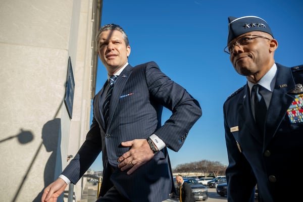 Defense Secretary Pete Hegseth walks into the Pentagon with Chairman of the Joint Chiefs of Staff Gen. Charles Q. Brown Jr., right, Monday, Jan. 27, 2025 in Washington. (AP Photo/Kevin Wolf)