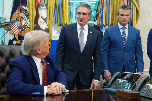 President Donald Trump and Defense Secretary Pete Hegseth listen as Interior Secretary Doug Burgum speaks in the Oval Office of the White House, Friday, May 23, 2025, in Washington. (AP Photo/Evan Vucci)
