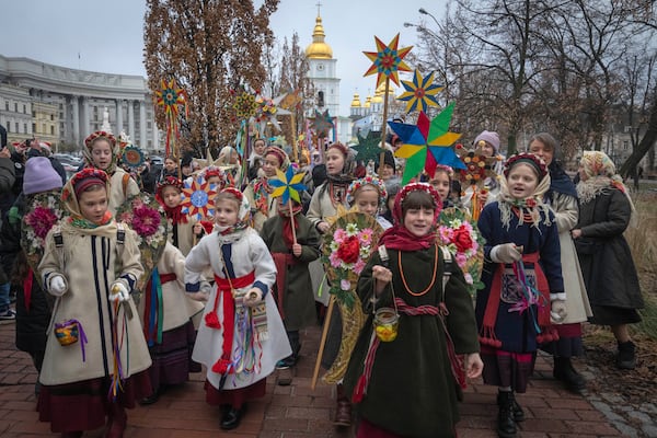 People wearing national suits sing carols as they celebrate Christmas near St. Michael Monastery in a city centre in Kyiv, Ukraine, Wednesday, Dec. 25, 2024. (AP Photo/Efrem Lukatsky)