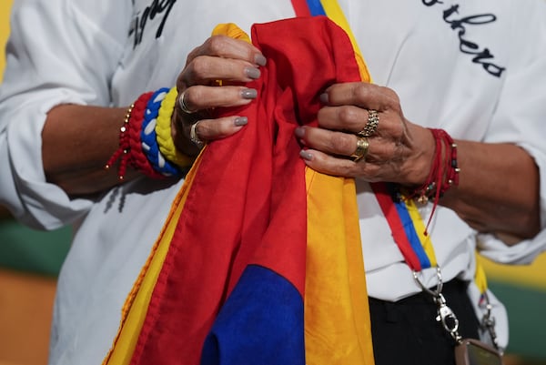 A woman holds a Venezuelan flag during a press conference by Venezuelan community leaders to denounce an end to the protections that shielded hundreds of thousands of Venezuelans from deportation, Monday, Feb. 3, 2025, in Doral, Fla. (AP Photo/Rebecca Blackwell)