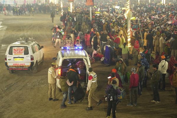 Security officers guide devotees into an ambulance at the site of a stampede on the Sangam, the confluence of the Ganges, the Yamuna and the mythical Saraswati rivers, on "Mauni Amavasya" or new moon day during the Maha Kumbh festival, in Prayagraj, Uttar Pradesh, India, Wednesday, Jan. 29, 2025. (AP Photo)