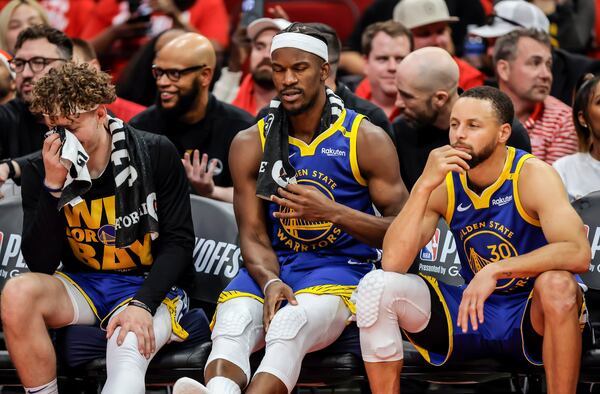 Brandin Podziemksi (2), Jimmy Butler (10) and Stephen Curry (30) react on the bench in the final seconds of the second half as the Golden State Warriors played the Houston Rockets in Game 5 of the First Round of the NBA Playoffs at Toyota Center in Houston, Texas on Wednesday, April 30, 2025. (Carlos Avila Gonzalez/San Francisco Chronicle via AP)