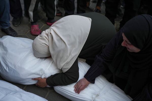 Mourners embrace the body of their relative who was killed in the Israeli bombardment of the Gaza Strip, during his funeral in Deir al-Balah, Wednesday, Jan. 15, 2025. (AP Photo/Abdel Kareem Hana)