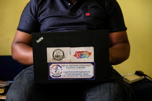 Ugandan human rights activist Kennedy Pius reads a letter from USAID on a laptop at home in Kampala, Uganda, Jan. 28, 2025. (AP Photo/Hajarah Nalwadda)