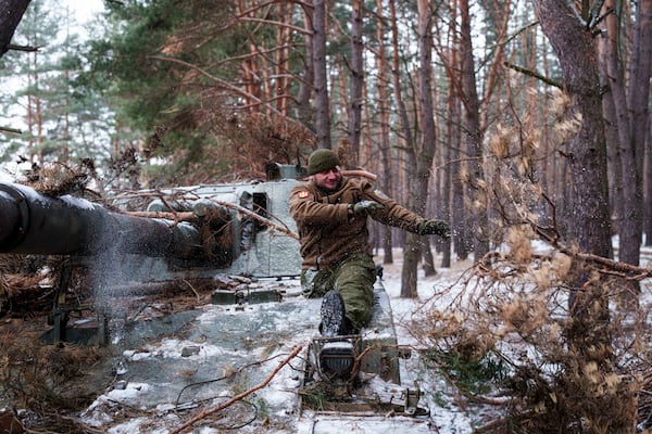 Leonid Lobchuk, a soldier with Ukraine's 127th brigade who lost a leg in combat in eastern Ukraine in 2015, takes the camouflage off his self-propelled howitzer in Ukraine's Kharkiv region on Feb. 10, 2025. (AP Photo/Evgeniy Maloletka)