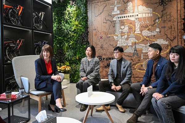 Britain's Chancellor of the Exchequer Rachel Reeves, 1st left, talks with the employees of Brompton flagship store in Beijing, Saturday, Jan. 11, 2025. (Jade Gao/Pool Photo via AP)